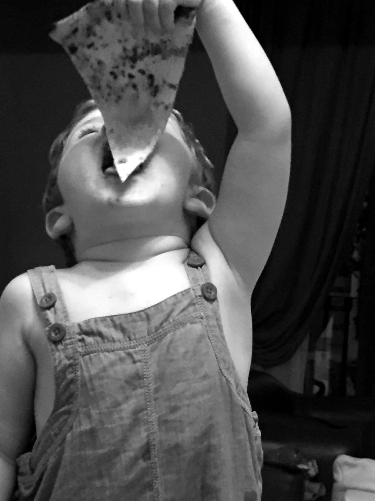 Nanni, the youngest of the family, eating a slice of pizza